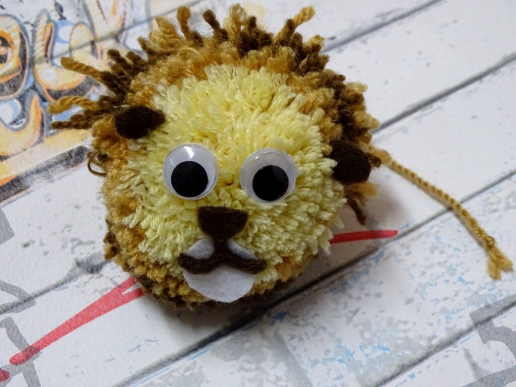 Der Löwe aus Wollresten ist ein cooles Upcycling-DIY-Projekt zum Basteln mit Kindern.
