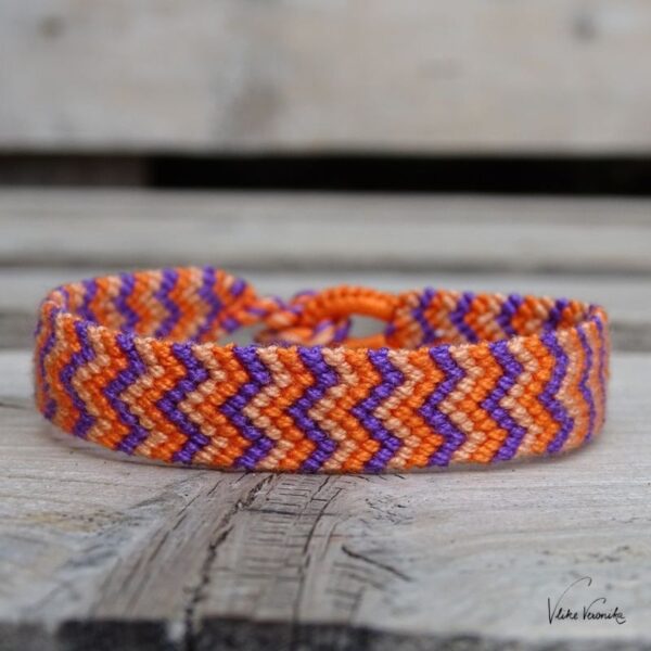 Geknüpftes Armband mit W-Muster in drei Farben (Orange, Pfirsich und Violett).
