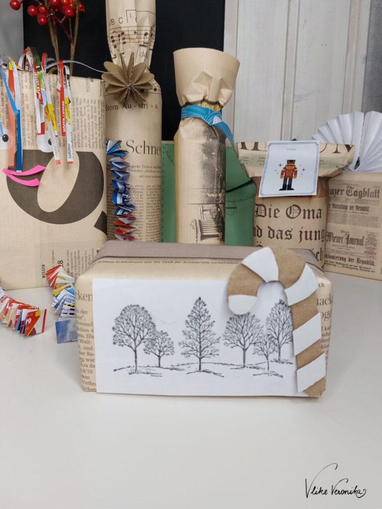Verpacke Geschenke in Zeitungspapier und gestempelten Motiven.