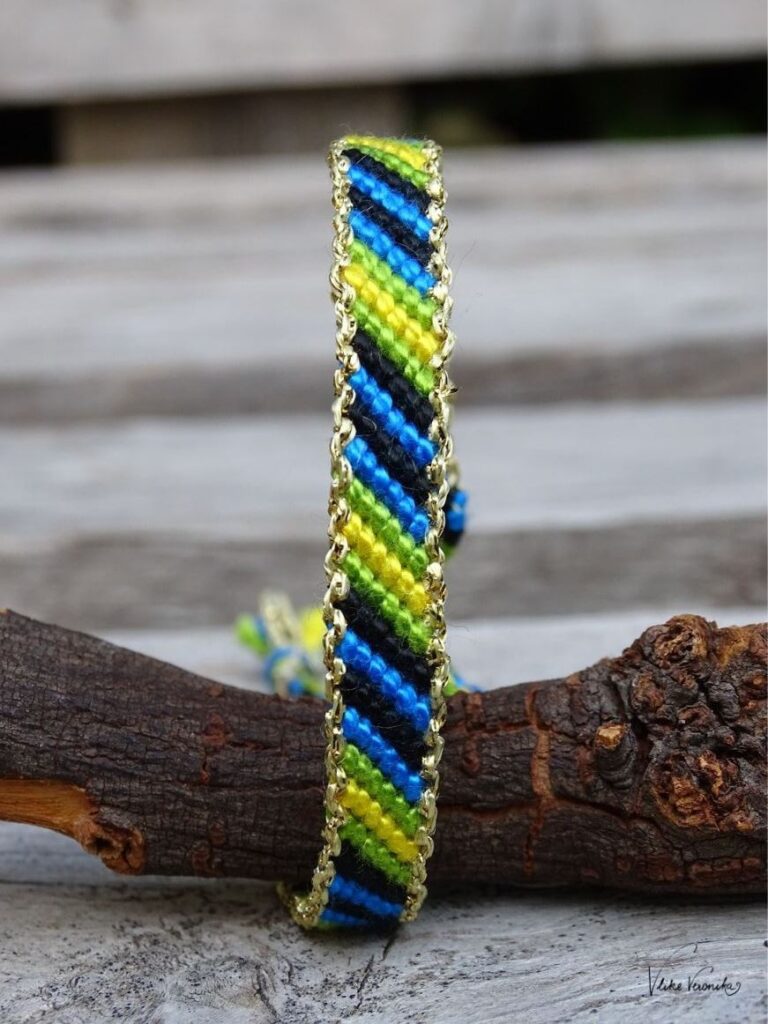Knüpfe dir Freundschaftsbänder in vier Farben wie hier das Linienmuster mit goldenem Garn am Rand sowie in Schwarz, Grün, Gelb und Blau.