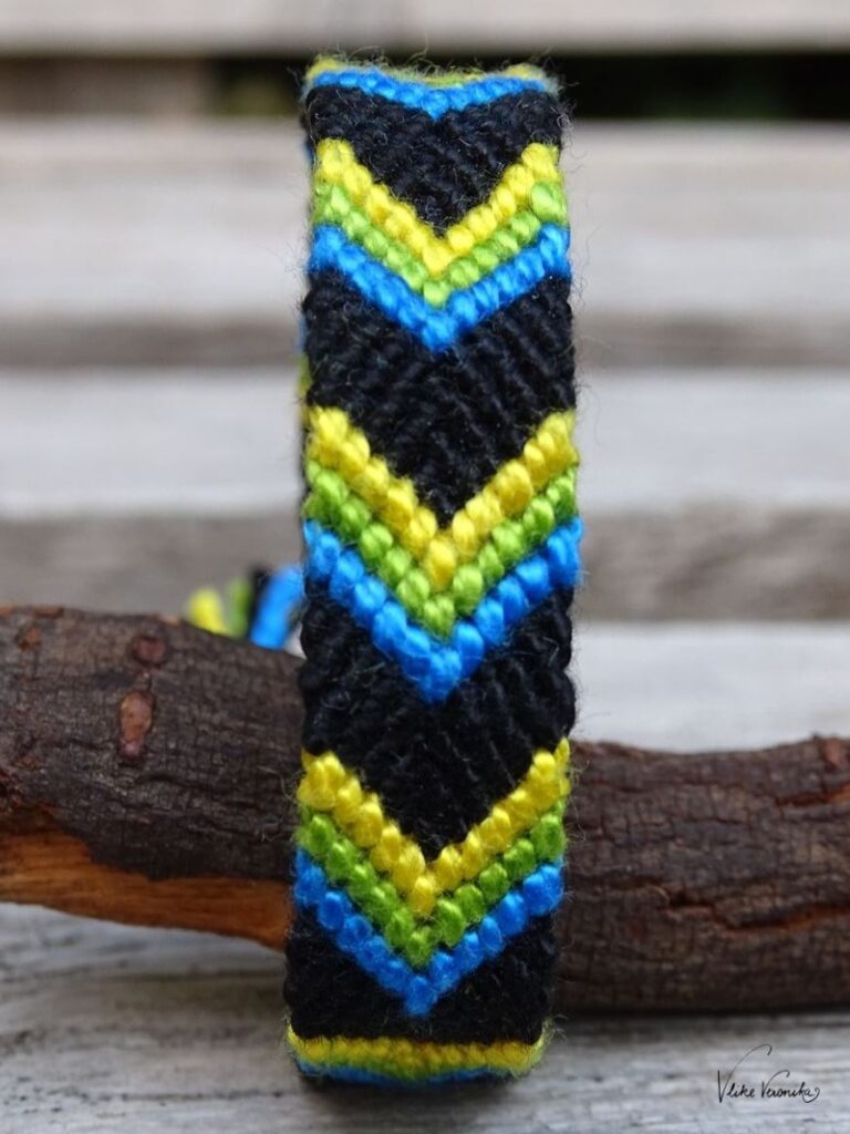 Knüpfe dir Freundschaftsbänder in vier Farben wie das V-Muster mit Twist in Schwarz, Grün, Gelb und Blau.