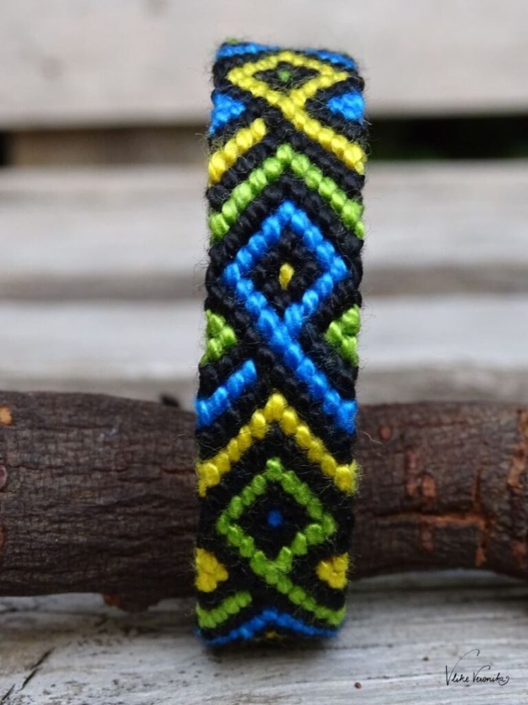 Knüpfe dir Freundschaftsbänder in vier Farben wie hier das verschränkte Fischmuster in Schwarz, Grün, Gelb und Blau.