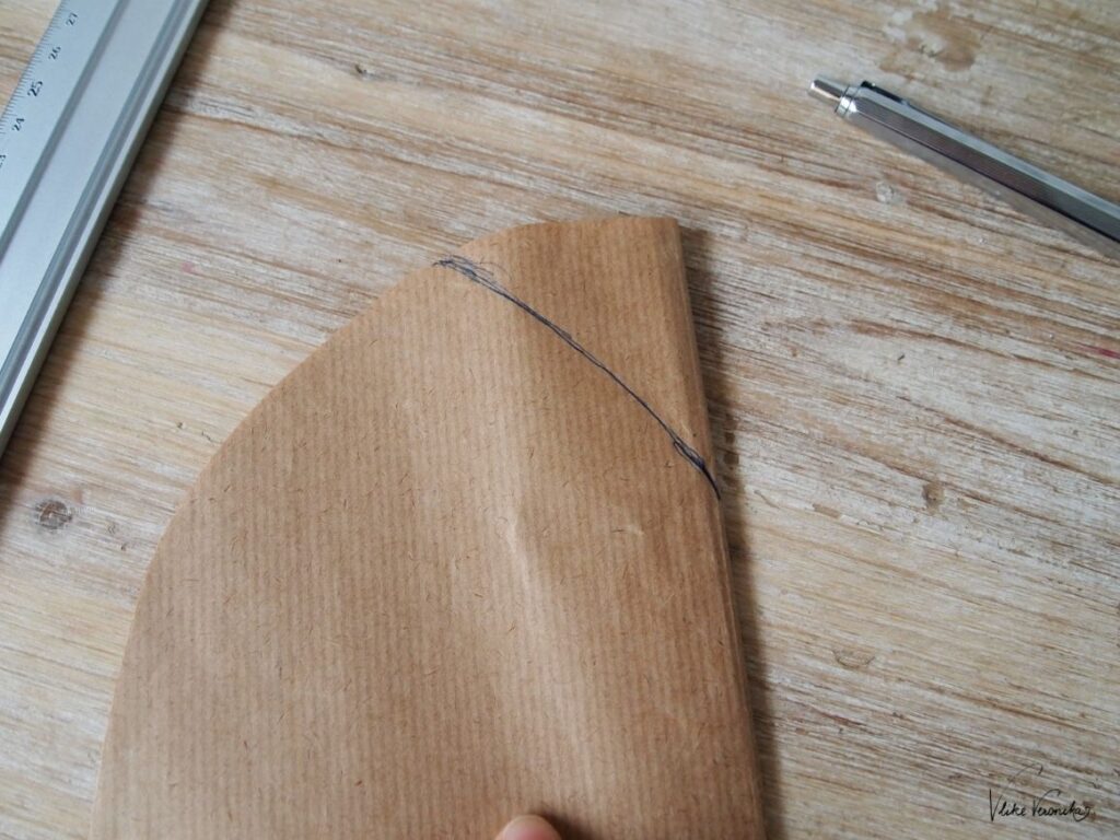 Zeichne dir eine kleine Krümmung in Form einer Bischofsmütze auf dein Beanie-Schnittmuster.
