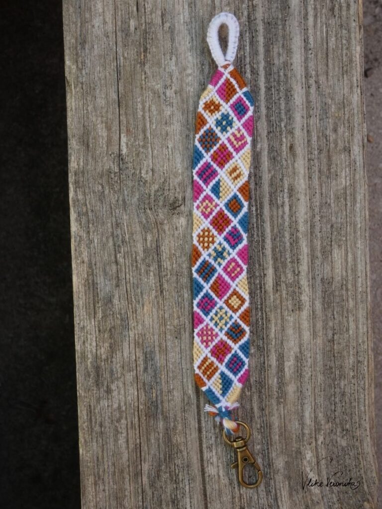 Geknüpftes Patchworkmuster in Magenta, Beige, Petrol und Ocker mit Loop-Verschluss und Karabinerhaken